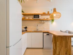 een keuken met witte kasten en een houten aanrecht bij Apartamento MOJO a 100mts de la playa de Corralejo in Corralejo