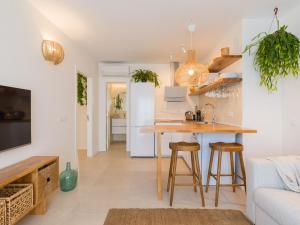 een keuken en een woonkamer met een tafel en stoelen bij Apartamento MOJO a 100mts de la playa de Corralejo in Corralejo