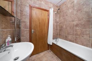 a bathroom with a bath tub and a sink at Omega - 3BD Gem in De Beauvoir Town in London