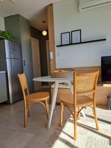 a kitchen with a table and two chairs and a refrigerator at Apartamento no coração de Bento Gonçalves in Bento Gonçalves +21 photos