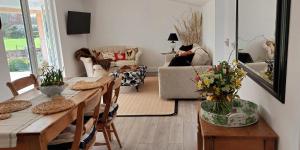 een woonkamer met een tafel en stoelen en een bank bij Garden Cottage in heart of Kent in Kent