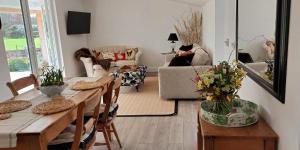 a living room with a table and chairs and a couch at Garden Cottage in heart of Kent in Kent