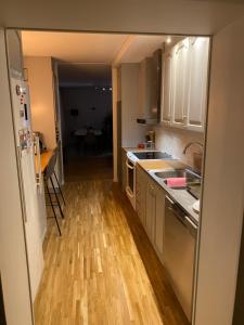 a kitchen with stainless steel appliances and a wooden floor at Bedrooms for rent in a Villa Eurovisionsguests in Staffanstorp