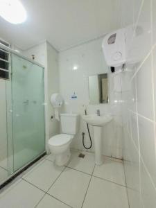 uma casa de banho com um WC, um chuveiro e um lavatório. em Dom Pedro Hotel em Petrópolis