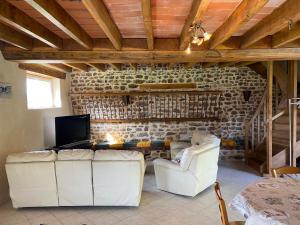 een woonkamer met 2 witte stoelen en een tv bij Le Petitepinay in Moitron-sur-Sarthe