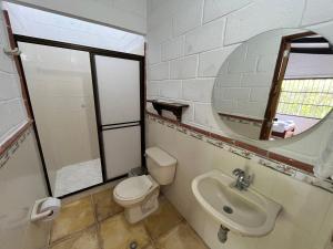 a bathroom with a toilet and a sink and a mirror at Cabaña Pazatiempo Sapzurro in Sapzurro