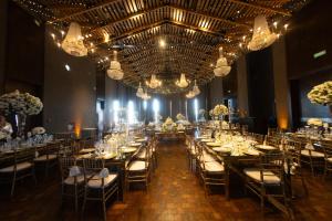 une salle de banquet avec des tables, des chaises et des lustres dans l'établissement Pueblo Nativo Resort Golf & Spa, à La Cumbre