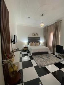 a bedroom with a bed and a checkered floor at Ditoro Boutique Hotel in Pretoria