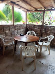 a wooden table and two chairs and a table and chairs at La Casa de Diego in Zorritos