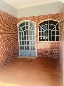 um quarto com duas portas e uma parede de tijolos em Villa JFK2 em Ouagadougou