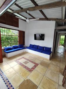 a living room with blue couches and a tv at Cabaña Pazatiempo Sapzurro in Sapzurro