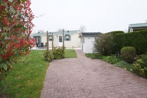 un vialetto di mattoni che conduce a una casa con garage di Kustverhuur, Groede, Paarlhof 53 a Groede