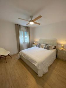 マラガにあるApartamento María Zambranoのベッドルーム(白いベッド1台、天井ファン付)