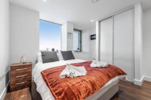 a bedroom with a large bed with a red blanket at New Apartment in Britannia point BP4 in London