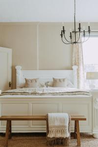 1 dormitorio con cama blanca y lámpara de araña en No. 5 East, en Winnipeg