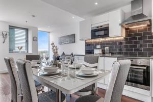 eine Küche und ein Esszimmer mit einem Tisch und Stühlen in der Unterkunft New Apartment in Britannia point BP4 in London