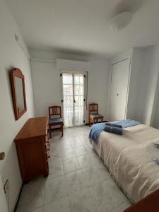 a bedroom with a bed and a table and chairs at Encantador apartamento frente al mar en Matalascañas: ¡Tu escapada perfecta! in Matalascañas