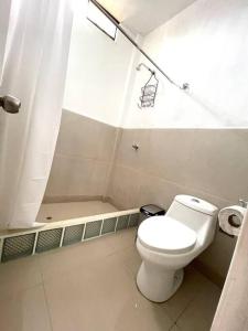 ein Badezimmer mit einem weißen WC und einer Dusche in der Unterkunft Terraviva Chincha® Casa de Campo Natural y hermosa in Chincha Baja