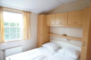 a small bedroom with a bed and a window at Kustverhuur, Groede, Paarlhof 53 in Groede