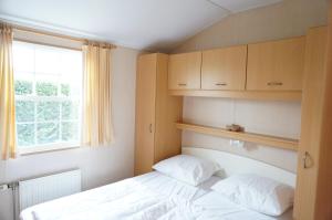 una piccola camera da letto con un letto e una finestra di Kustverhuur, Groede, Paarlhof 53 a Groede