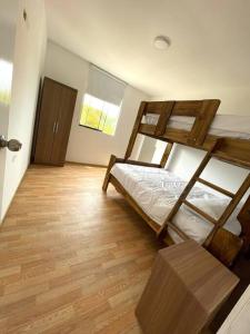 1 Schlafzimmer mit 2 Etagenbetten und Holzboden in der Unterkunft Terraviva Chincha® Casa de Campo Natural y hermosa in Chincha Baja