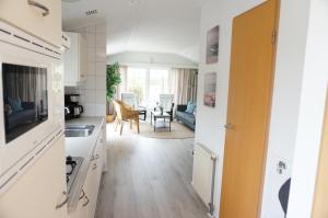 a kitchen and a living room with a table at Kustverhuur, Groede, Paarlhof 53 in Groede