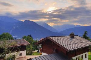uma casa com montanhas ao fundo em Apartment in der Alpenresidenz mit einem faszinierenden Ausblick em Berchtesgaden
