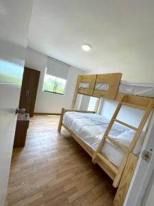 Chincha BajaにあるTerraviva Chincha® Casa de Campo Natural y hermosaのウッドフロアのベッドルーム1室(二段ベッド2組付)