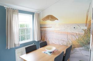 a dining room with a table and a view of the ocean at Kustverhuur, Groede, Paarlhof 53 in Groede