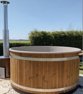 a wooden circular hot tub in a yard at empty spot on grass Camping The Tulip in Julianadorp