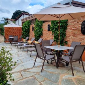 a patio with tables and chairs and an umbrella at Pouso 22 in Pirenópolis