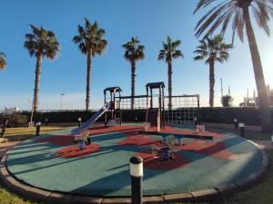 um parque infantil vazio com palmeiras ao fundo em Apartamento Azul Marino em Denia