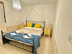 um quarto com uma cama com almofadas amarelas e azuis em Lovely Apartment em Stintino