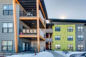 an apartment building with a yellow and gray building at Modern Bozeman Condo with Balcony and Mountain Views! in Bozeman