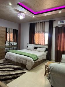 a bedroom with two beds and a purple lighting at Bedouin family home in Wadi Musa
