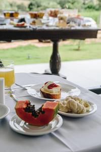 a table with two plates of food on a table at Pousada Casa Vista Bela São José da Barra Capitólio in São José da Barra