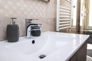 umywalkę w łazience z kranem na górze w obiekcie Adriana sweet apartment w Rzymie