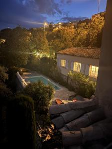 - une vue sur une maison avec une piscine la nuit dans l'établissement les petites terrasses, à Grasse