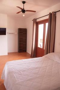 a bedroom with a bed and a ceiling fan at Apto com vista para Montanha - nr 1 in Garopaba
