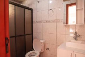 a bathroom with a toilet and a shower and a sink at Apto com vista para Montanha - nr 1 in Garopaba