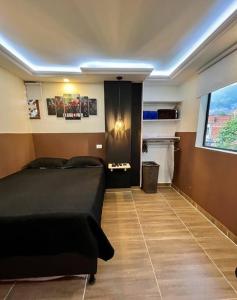 1 dormitorio con cama negra y ventana en 402 GTA Sandreas / la casa de papel, en Medellín