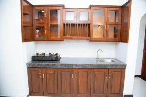 a kitchen with wooden cabinets and a sink at Tango Sunrise Villa in Tangalle +175 photos