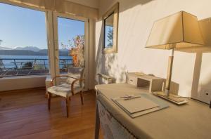 um quarto com uma secretária com um candeeiro e uma janela em Sol Arrayan Hotel & Spa em Villa La Angostura