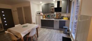 a small kitchen with a table and chairs in it at La Grange in Woignarue