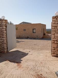 une porte ouverte dans un bâtiment en briques avec un mur en pierre dans l'établissement Harmonie des alizés, à Essaouira