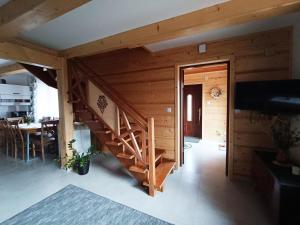a wooden house with a staircase and a dining room at Dom na Smyrakach in Zawoja