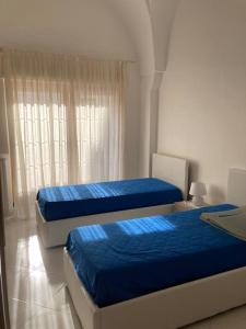 - une chambre avec 2 lits et une fenêtre dans l'établissement Appartamento in Salento, à San Vito dei Normanni