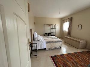 - une chambre avec un lit, une chaise et une fenêtre dans l'établissement Harmonie des alizés, à Essaouira