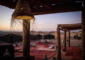 een kamer met uitzicht op een woestijn en een tent bij Desert Luxury Camp in Mhamid