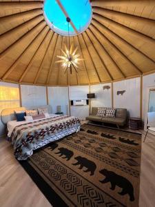 Valley Center的住宿－Glamping-Sky Dome Yurt-Tiny House-2 by Lavenders field，帐篷内一间卧室,配有一张床和一张沙发